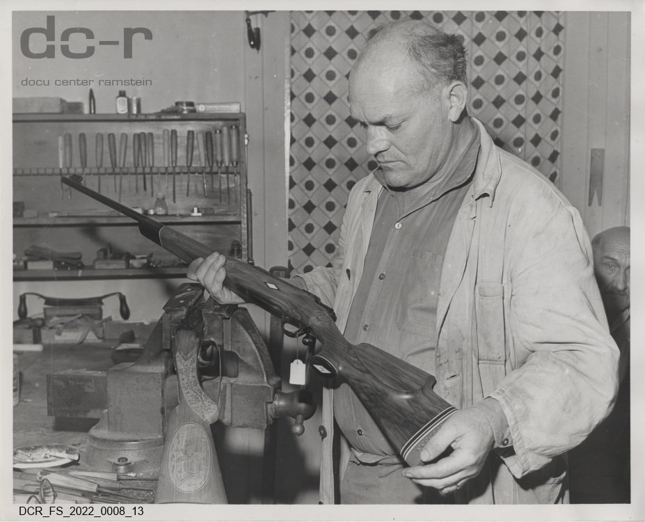 Schwarzweißfoto, Portraitaufnahme von Josef Fuchs mit einem fertig geschitzten Jagdgewehr ("dc-r" docu center ramstein RR-F)