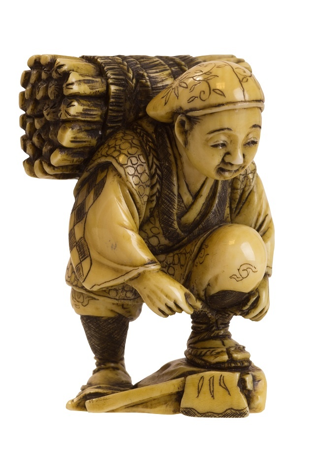 Katabori-Netsuke eines Brennholzsammlers, seine Sandale bindend mit Brennholzbündel auf dem Rücken, (Stadtmuseum Simeonstift Trier RR-R)