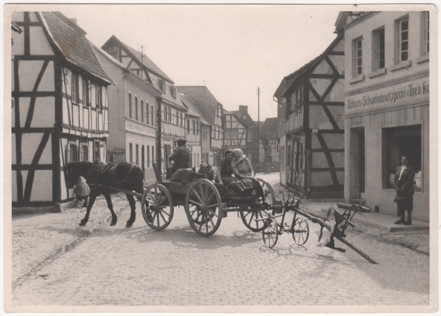 Pferdegezogener Leiterwagen mit angehängtem Pflug biegt von Hauptstraße in Schulstraße ein (Heimatmuseum und -Archiv Bad Bodendorf CC BY-NC-SA)
