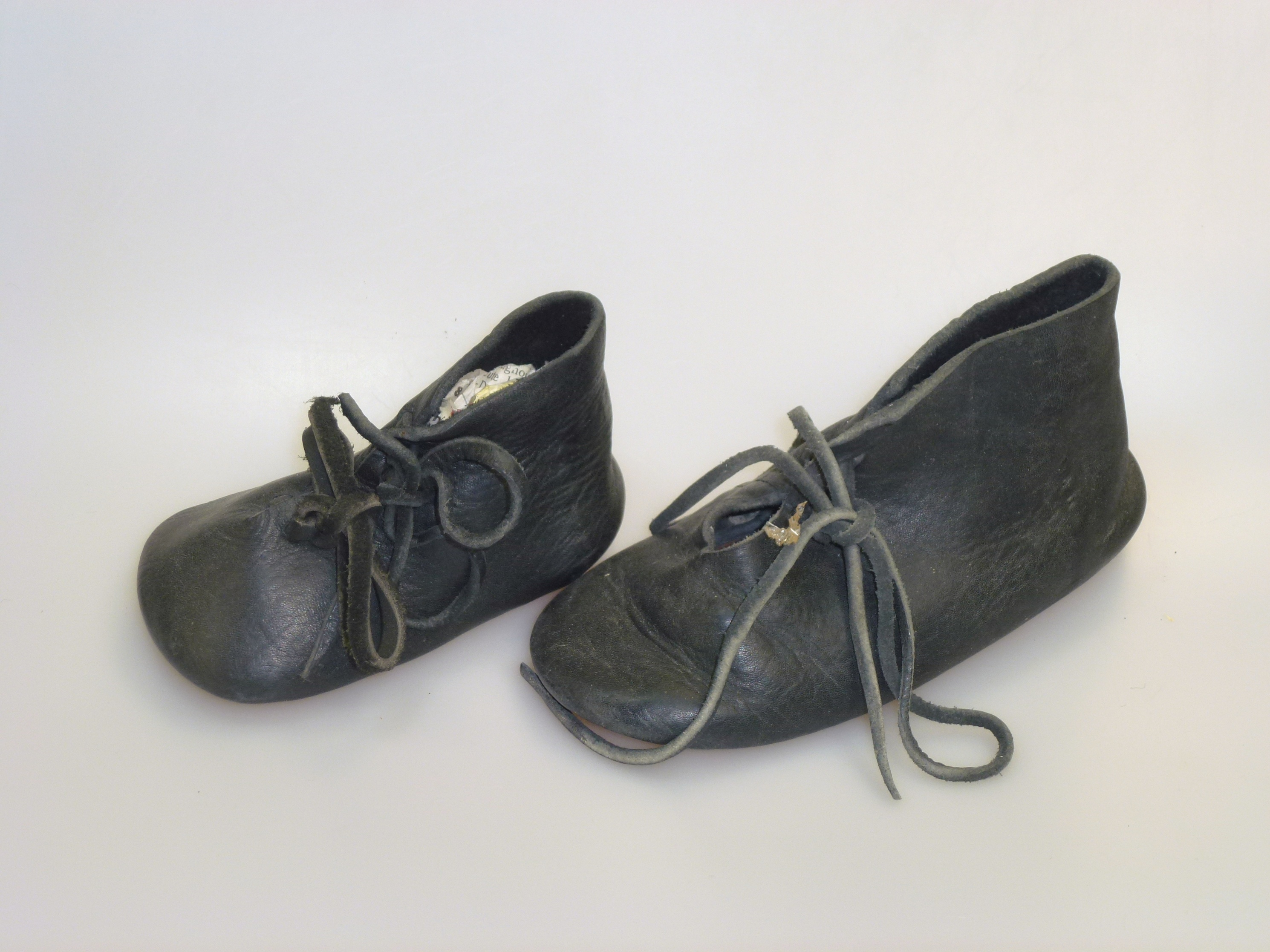 Zwei einzelne Schnürschuhe aus Leder für Kinder (Deutsches Schuhmuseum Hauenstein CC BY-NC-SA)