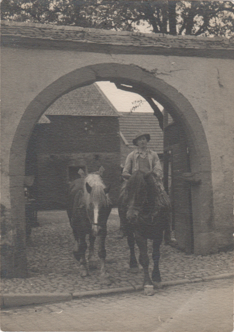 Reiter mit Zusatzpferd reitet durch Toreinfahrt (Heimatmuseum und -Archiv Bad Bodendorf CC BY-NC-SA)