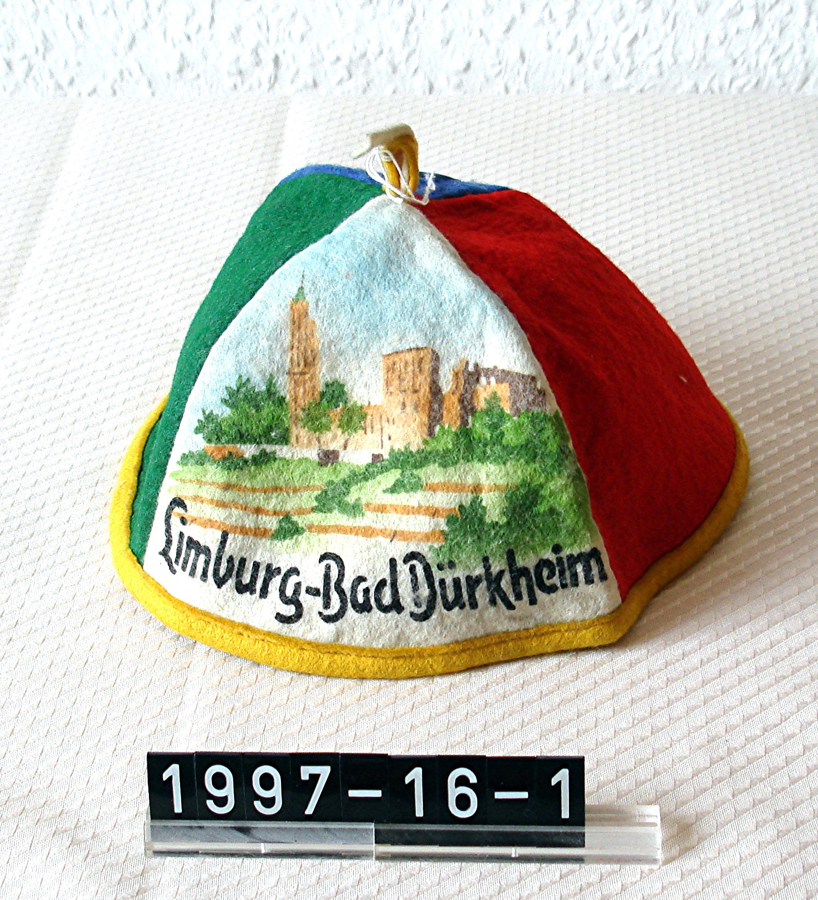 Mütze aus buntem Filz; mit gedrucktem Bild: "Limburg-Bad Dürkheim"; um 1920 (Stadtmuseum Bad Dürkheim, Museumsgesellschaft Bad Dürkheim e.V. CC BY-NC-SA)
