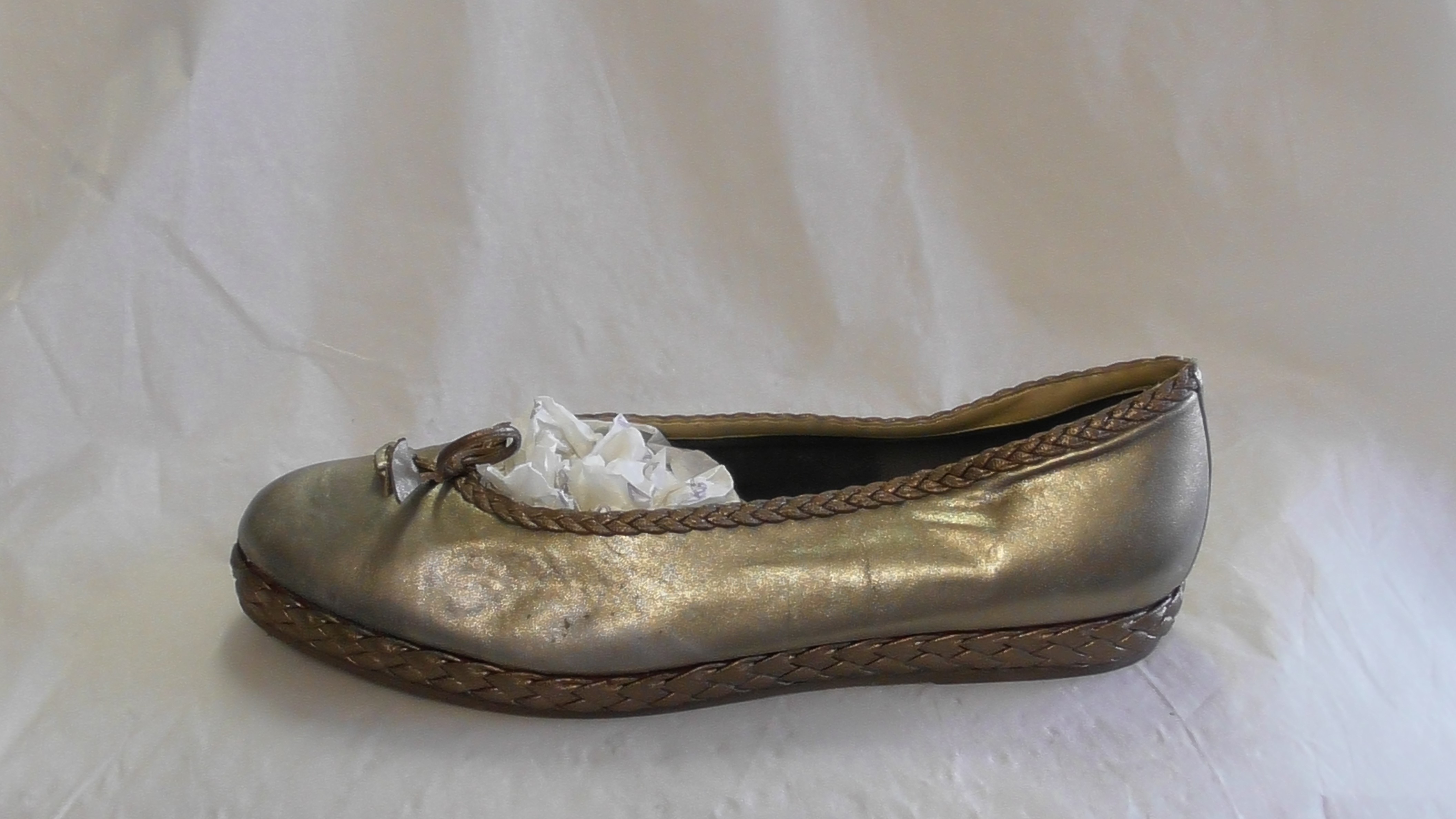 Goldene Damen-Slipper mit Zierschleife und geflochtenen Rändern (Deutsches Schuhmuseum Hauenstein CC BY-NC-SA)
