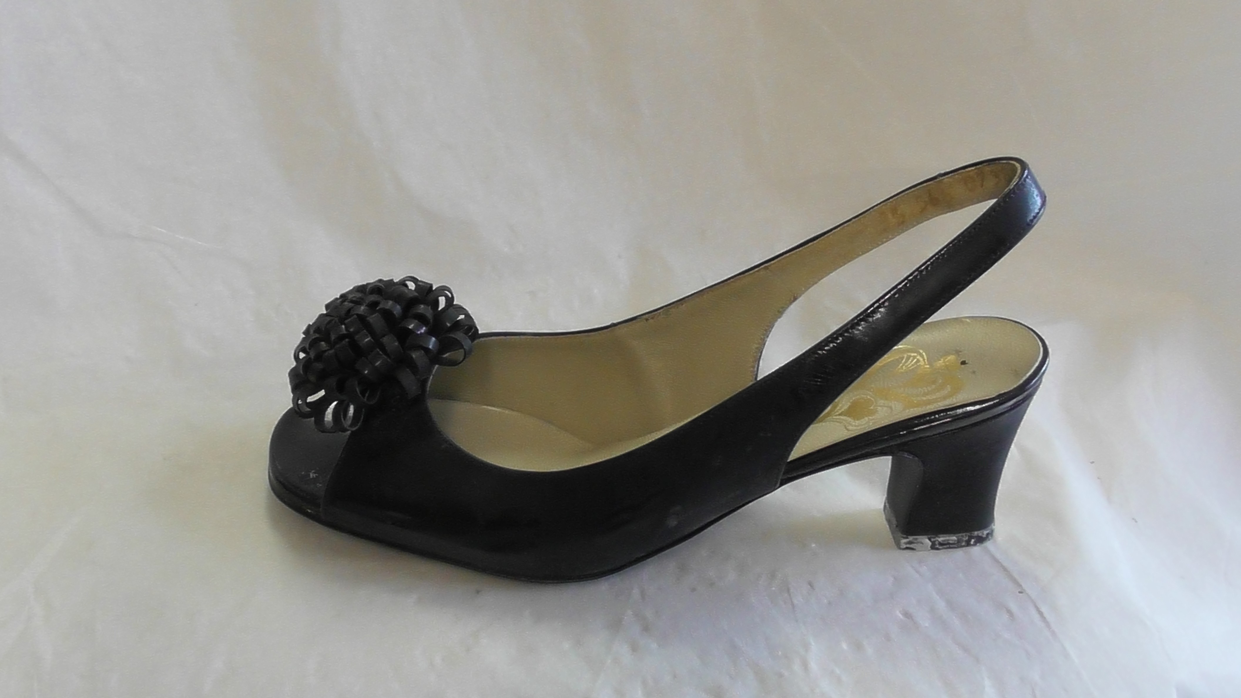 Schwarze Damensandaletten aus Lackleder mit Pompon, linker Schuh (Deutsches Schuhmuseum Hauenstein CC BY-NC-SA)