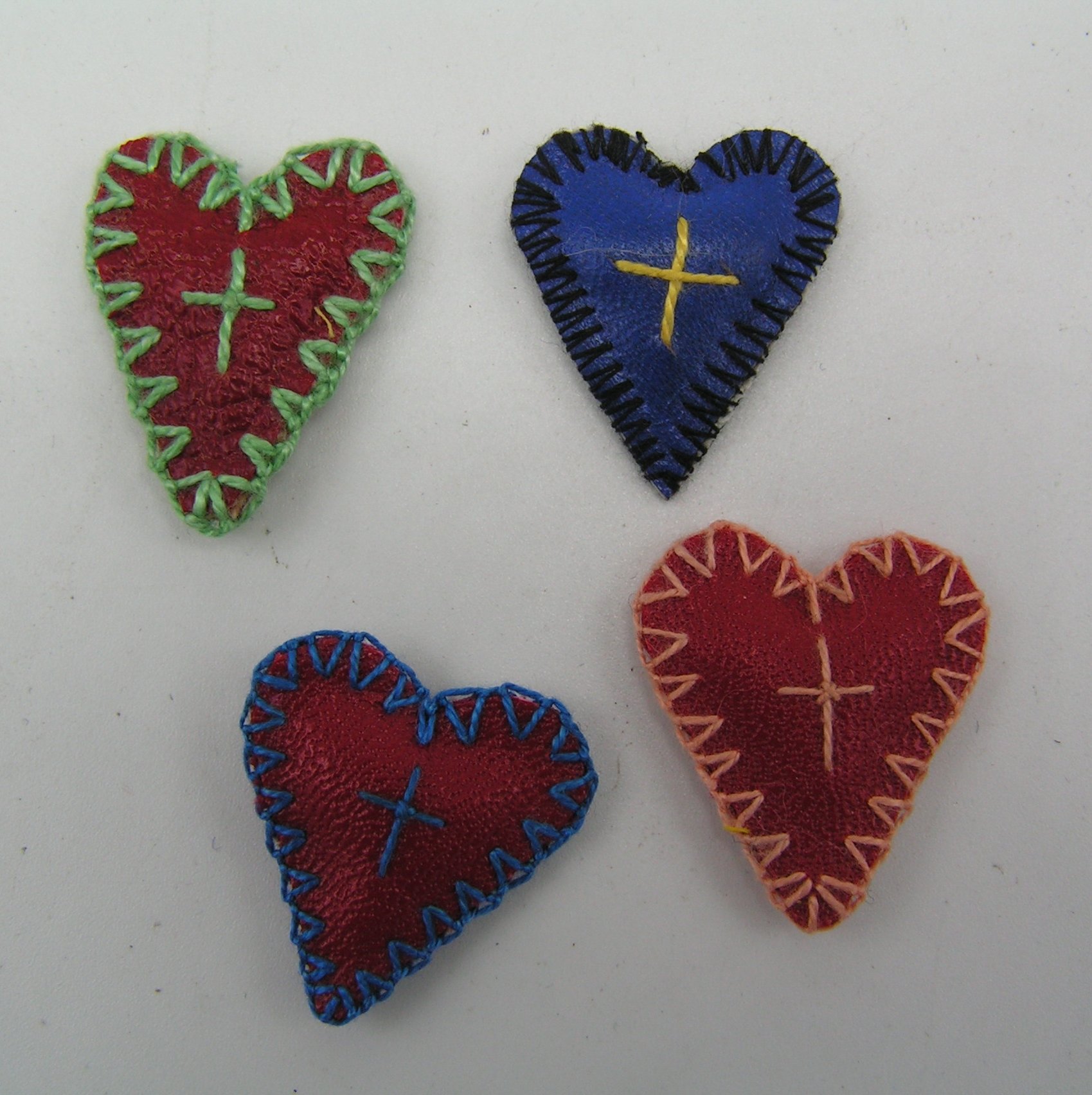 Vier Herzen aus Leder oder Kunstleder mit eingenähten kleinen Wachspäckchen (Freilichtmuseum Roscheider Hof CC0)