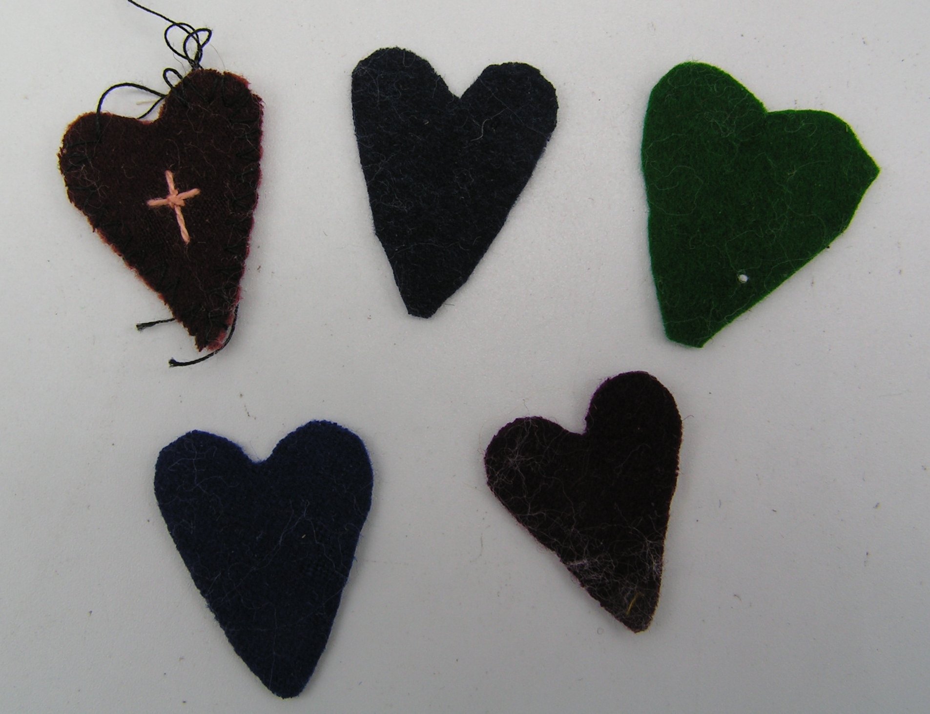 4 ausgeschnittene Herzstücke und ein unfertiges Herz aus Wollfilz (Freilichtmuseum Roscheider Hof CC0)