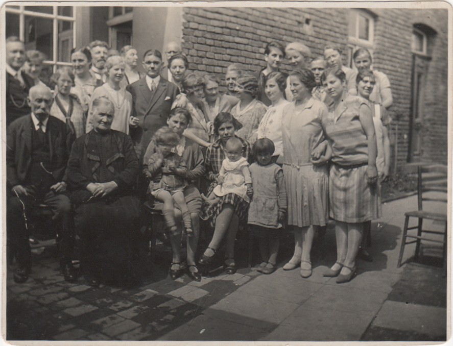 Gäste der Pension Lorscheid im Gruppenfoto vor einer Mauer im Garten (Heimatarchiv Bad Bodendorf CC BY-NC-SA)