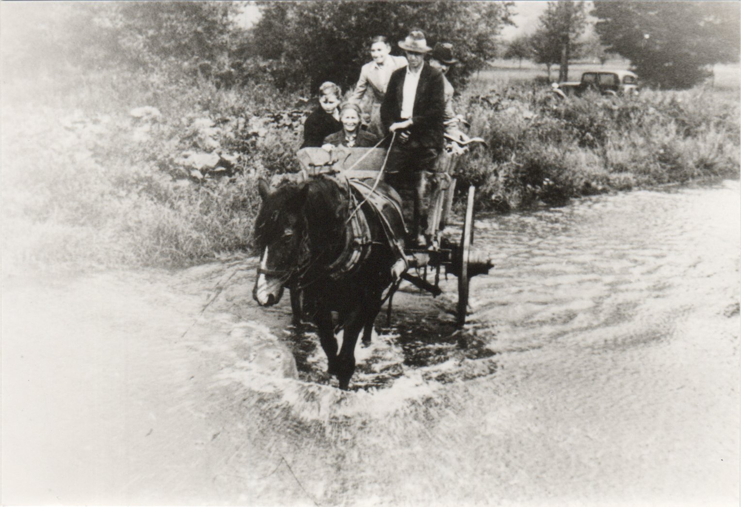 Kurgäste werden hier 1935 mit Pferdewagen durch die Ahr zur Kuranwendung gefahren (Heimatarchiv Bad Bodendorf CC BY-NC-SA)