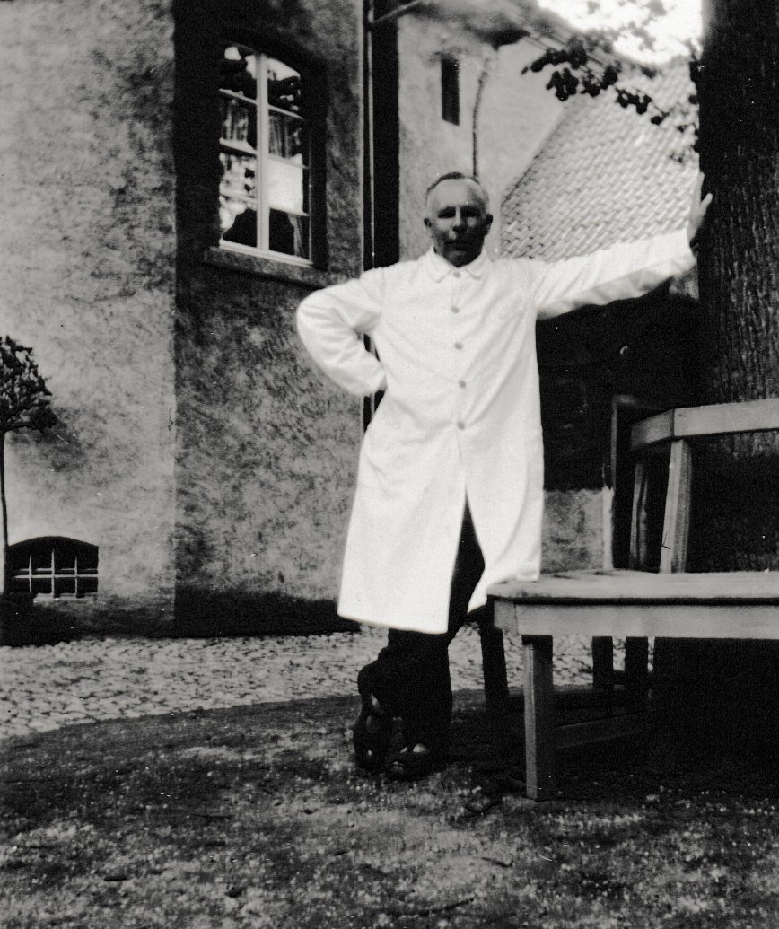 Nikolaus Leisen im weißen Behandlungskittel im Burghof (Dr. Jürgen Haffke CC BY-NC-SA)