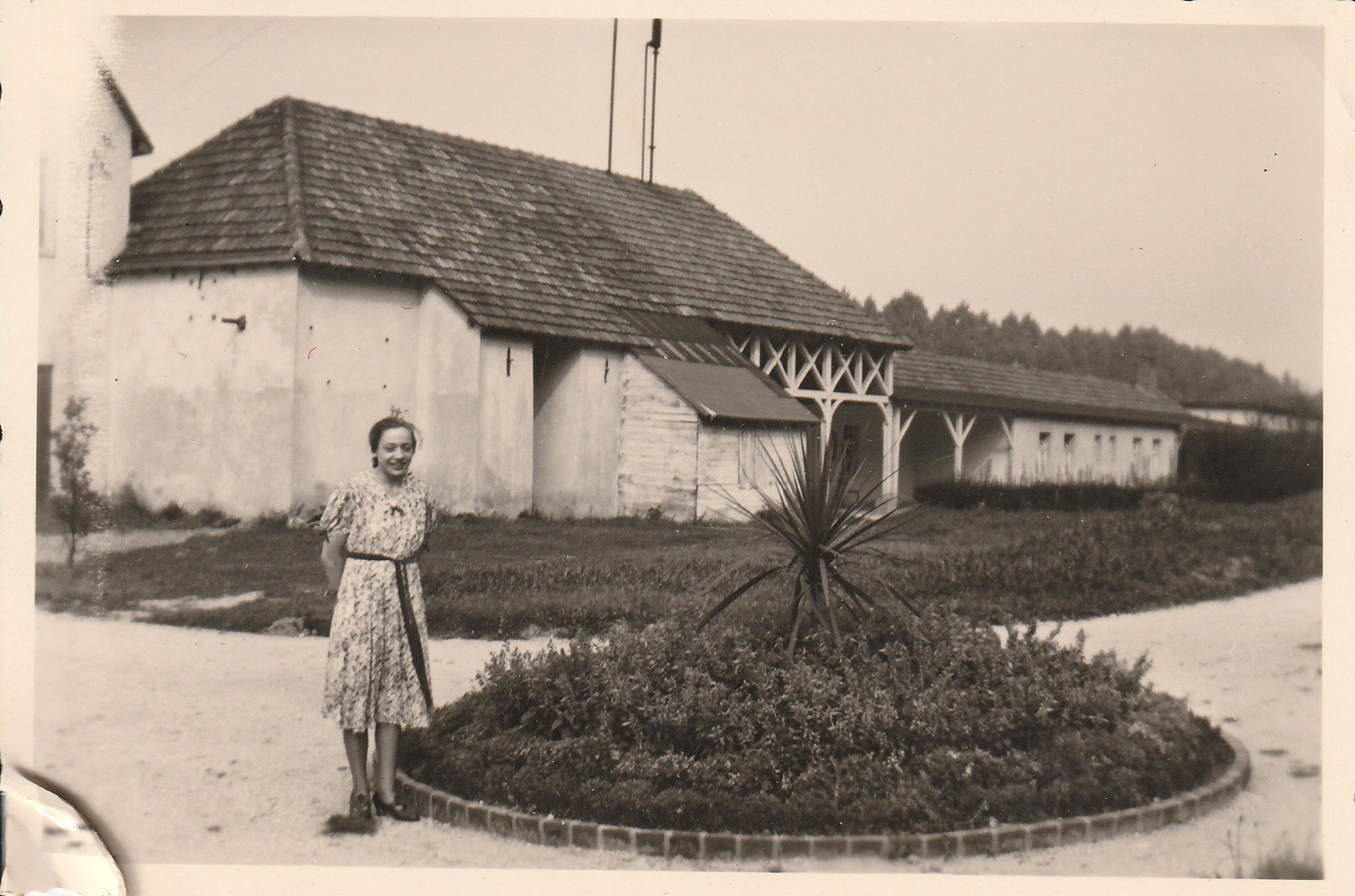 Junge Frau steht vor einer Blumeninsel hinter dem Kohlensäure-Werk St. Josepf in Bodendorf/Ahr (Roswitha Schönberg, Hauptstraße 29, 56745 Hausten CC BY-NC-SA)