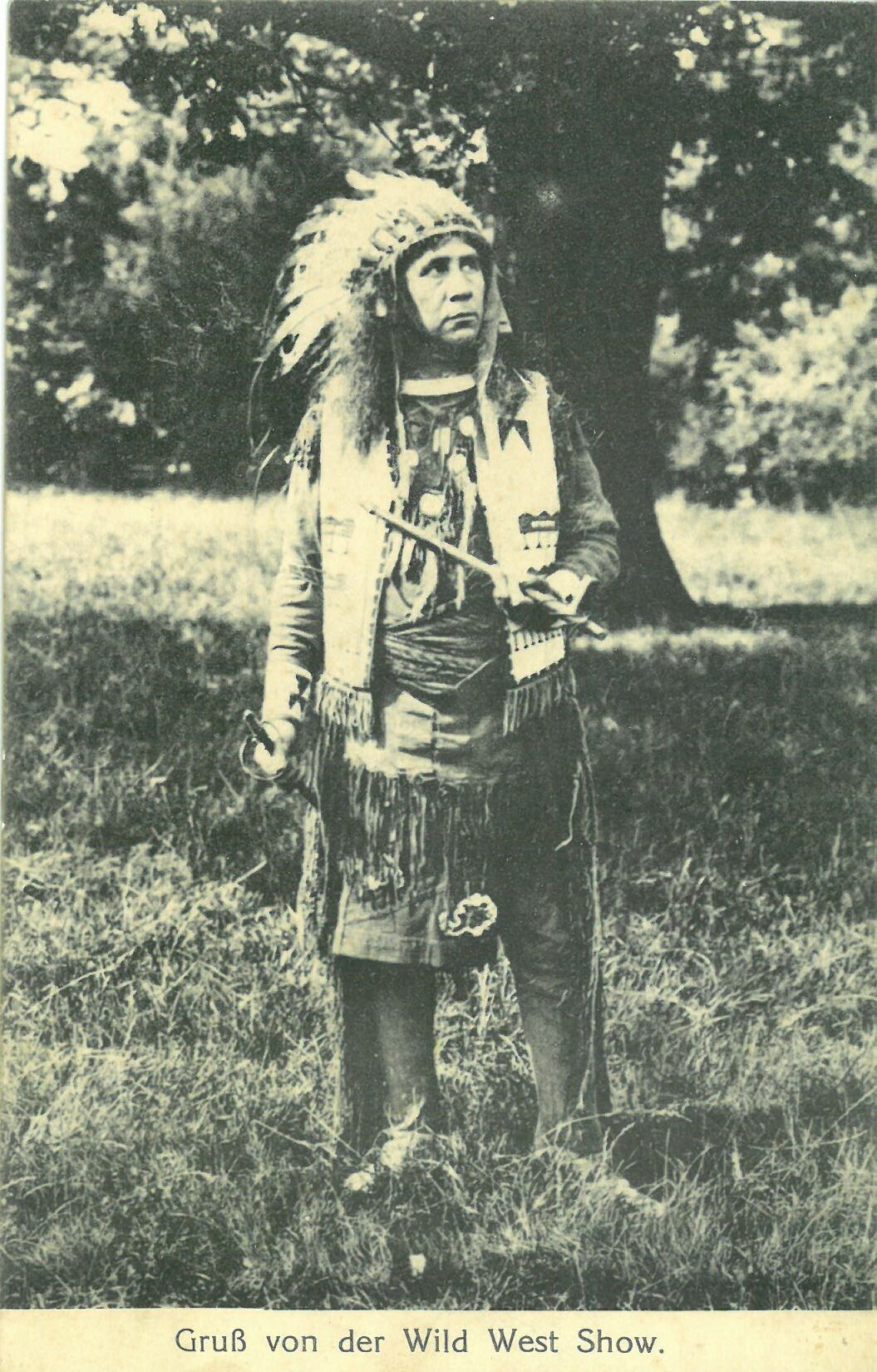 Wild West Show der Deer Family; Mann in indigener Kleidung mit Friedenspfeife (Karl-May-Museum gGmbH RR-R)
