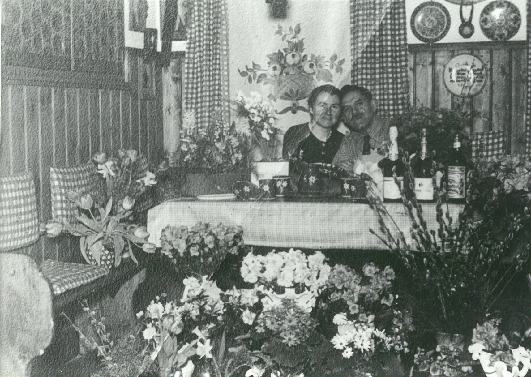 Patty Frank und Frau Marie Tobis am Tisch sitzend, von Blumensträußen umringt (Karl-May-Museum gGmbH RR-R)
