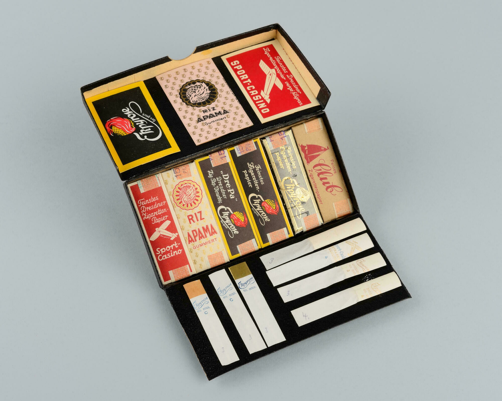 Musterpackung für Zigarettenpapiere der Marken "Ekpyrose, RIZ APAMA, SPORT-CASINO" (Stadtmuseum Dresden CC BY-NC-ND)