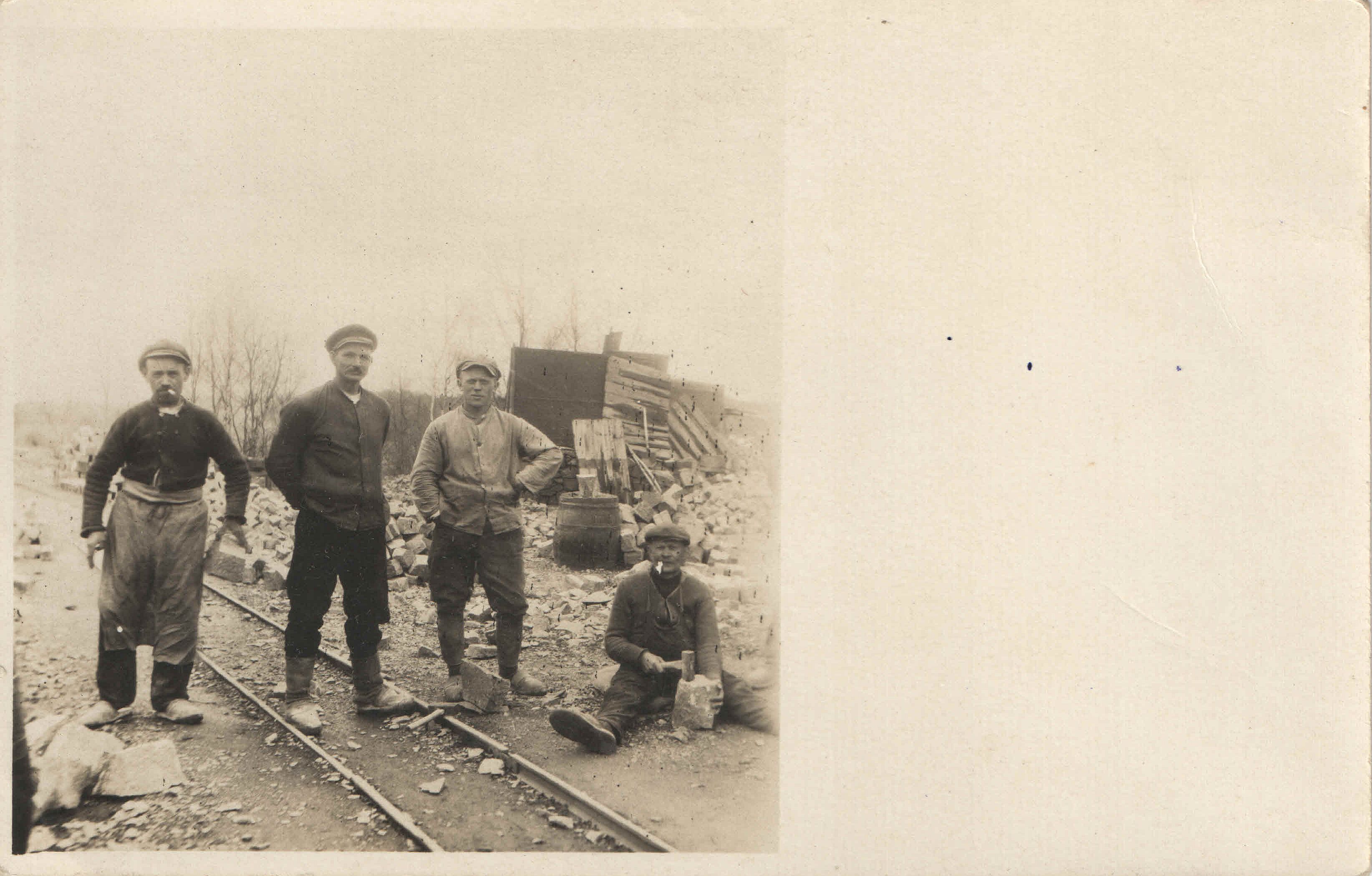 Vier Steinarbeiter auf einem Feldbahngleis (Museum Steinarbeiterhaus Hohburg CC BY-NC-SA)