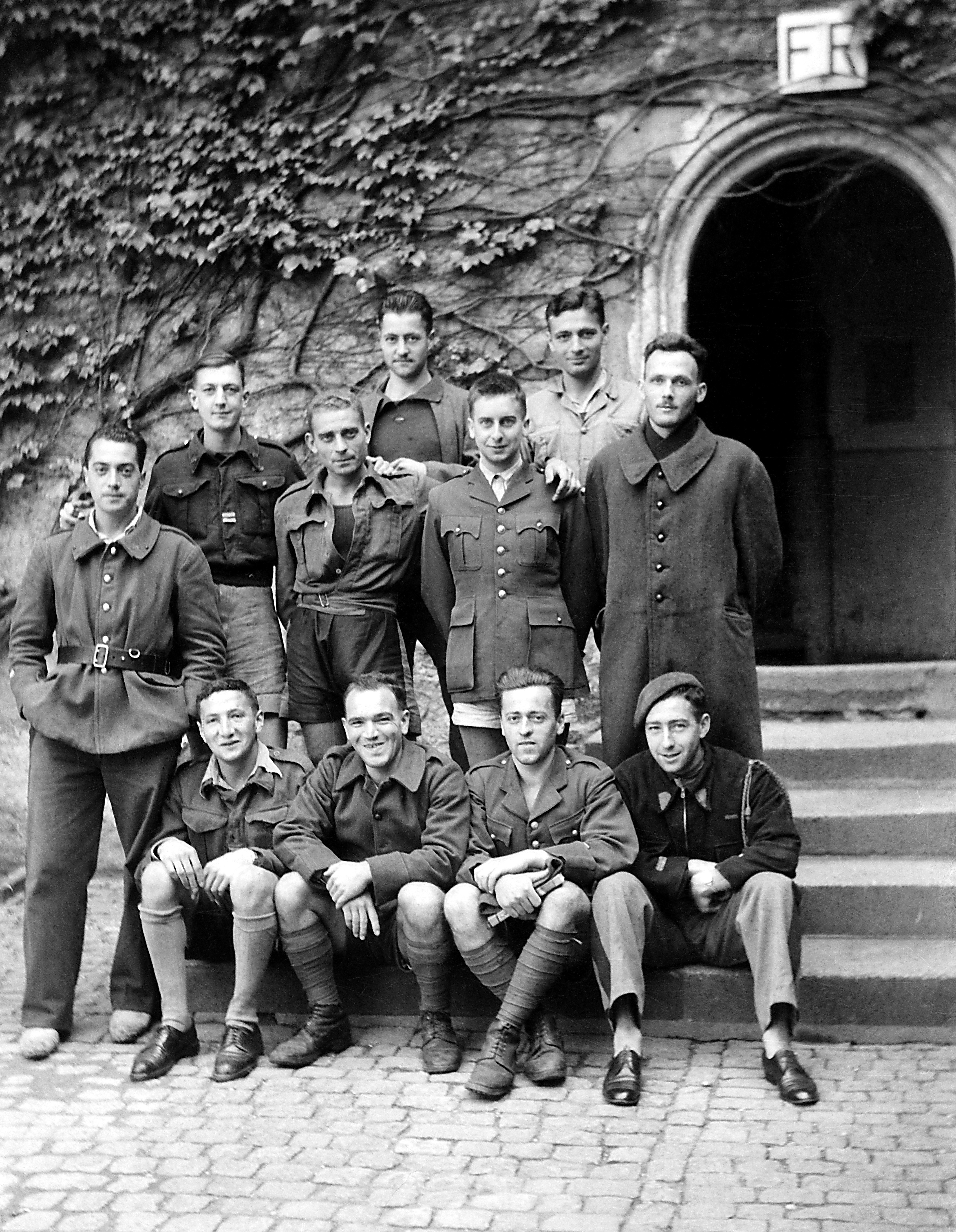 Französische (?) Kriegsgefangene, wahrscheinlich Ordonnanzen, stehen bzw. sitzen vor dem rechten Eingang des Fürstenhauses (SBG gGmbH CC BY-NC-SA)