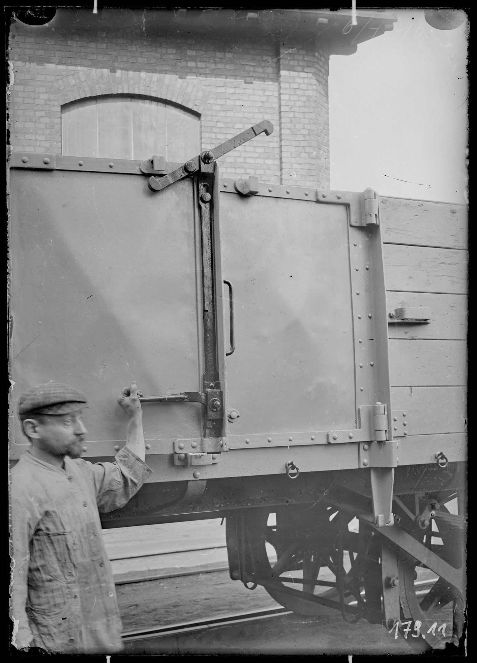 Fotografie: offener Güterwagen (Schrägansicht), Längsseitentürverschluss gelöst mit Person, 1910. (Verkehrsmuseum Dresden CC BY-NC-SA)