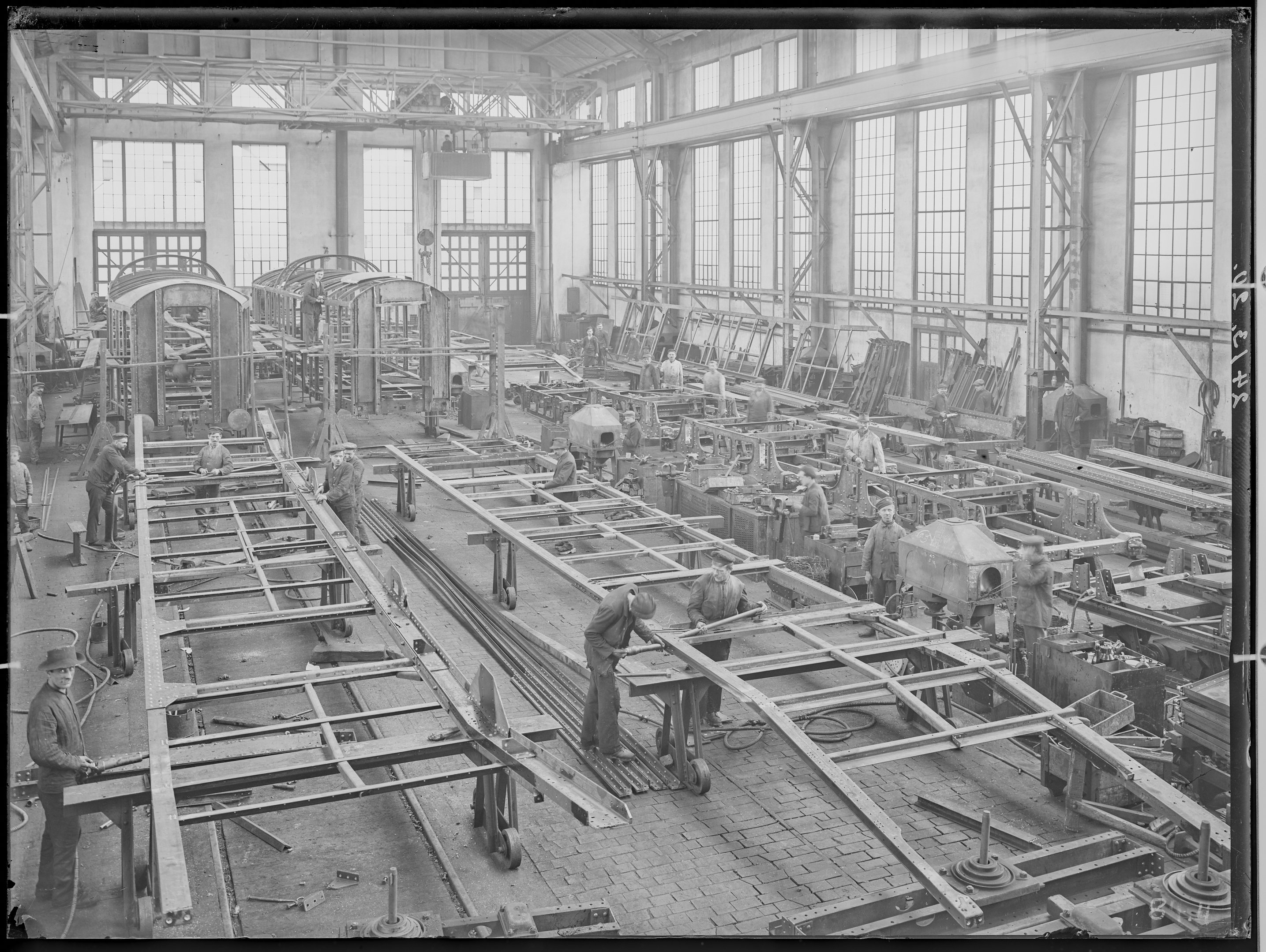 Fotografie: Gestellbau der Waggonfabrik Görlitz Aktiengesellschaft (Innenansicht), Werkhalle mit Personen bei der Arbeit, 1920. (Verkehrsmuseum Dresden CC BY-NC-SA)