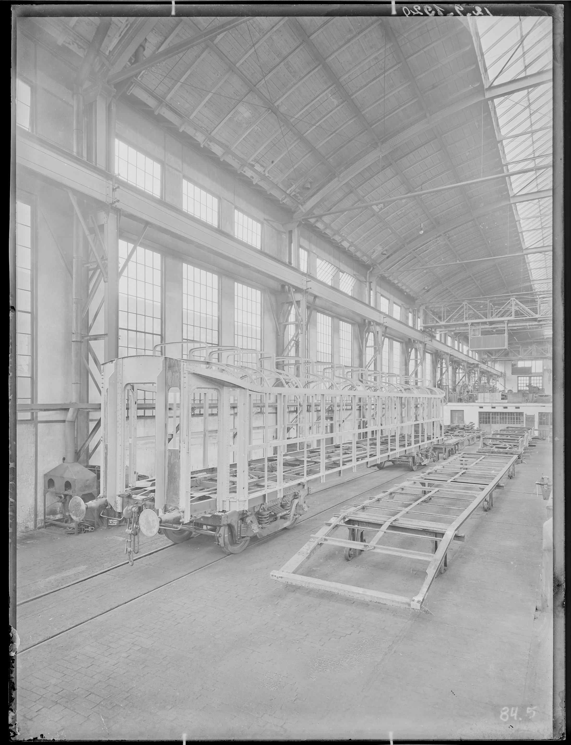 Fotografie: Gestellbau der Waggonfabrik Görlitz Aktiengesellschaft (Innenansicht), Werkhalle mit Kastengerippe und Untergestell, 1920. (Verkehrsmuseum Dresden CC BY-NC-SA)