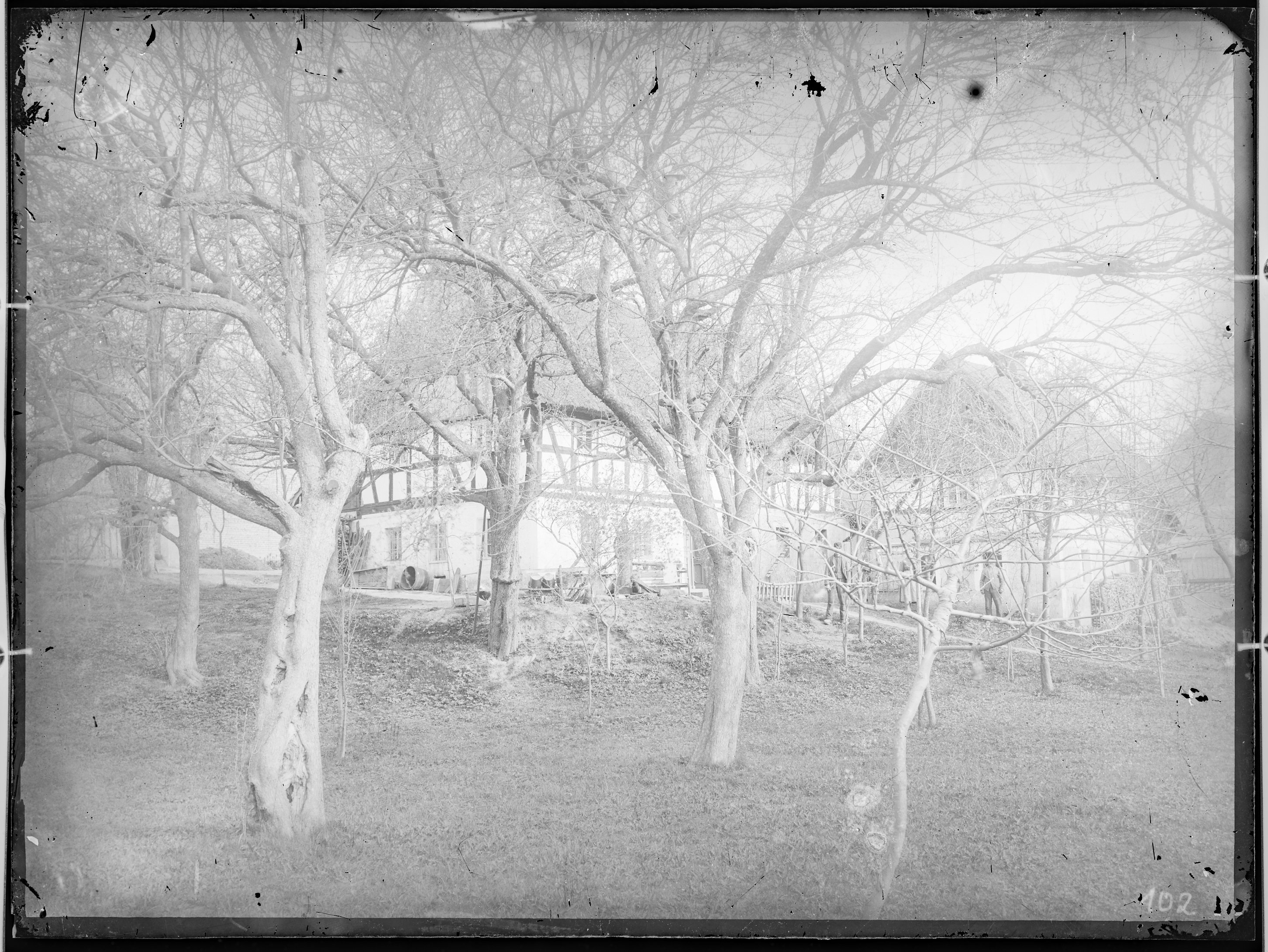 Fotografie: Wohngebäude und davor stehende Personen (Außenansicht), im Vordergrund Wiese mit Bäumen, um 1905? (Verkehrsmuseum Dresden CC BY-NC-SA)