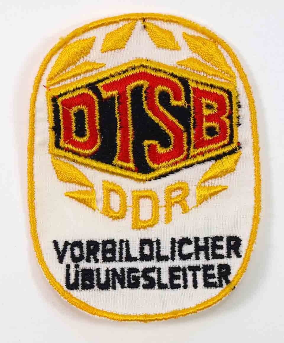 Aufnäher des Deutschen Turn- und Sportbundes der DDR, Vorbildlicher Übungsleiter (Museum Weißenfels - Schloss Neu-Augustusburg CC BY-NC-SA)