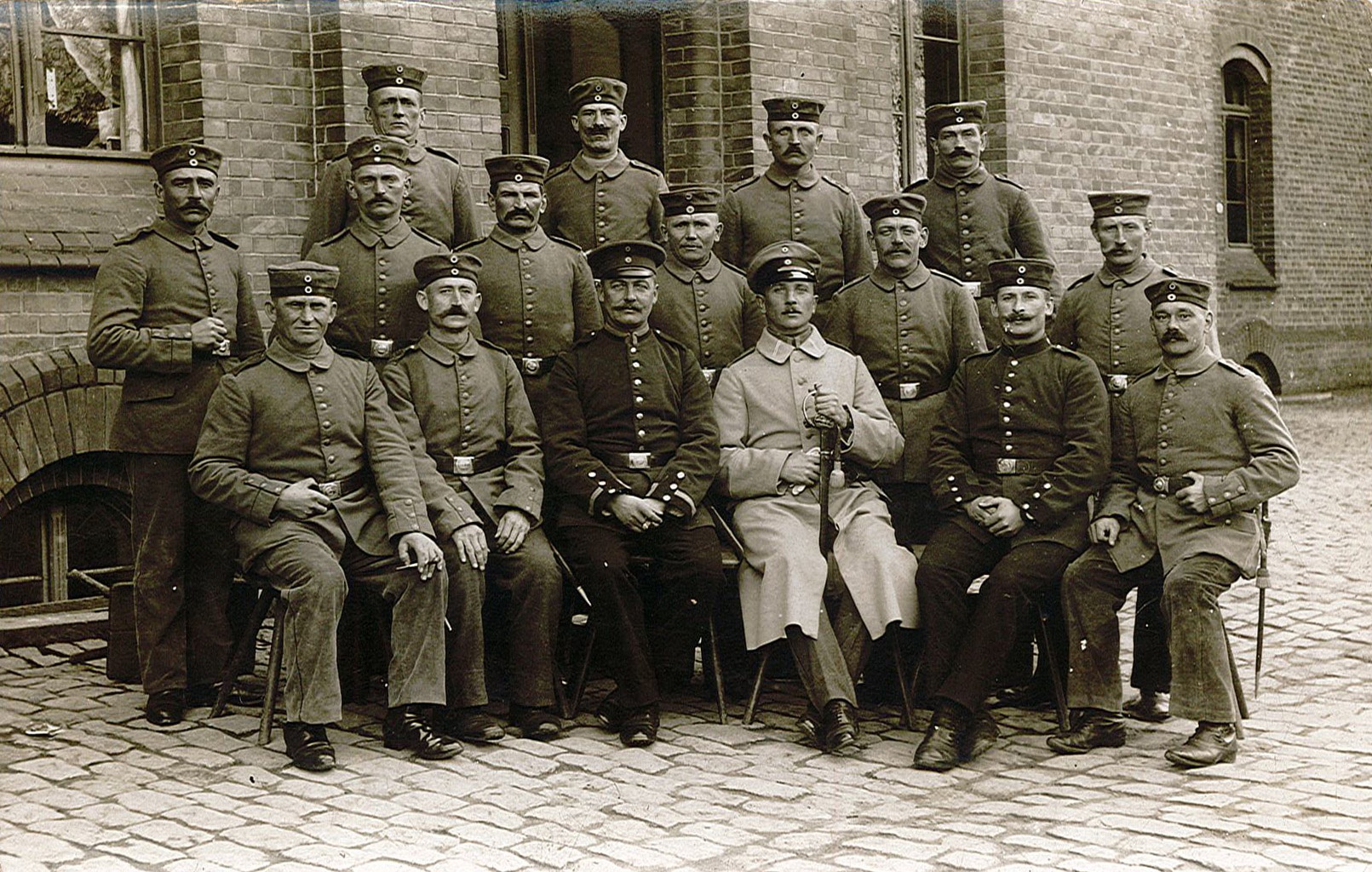 Fotopostkarte mit Gruppenbild von Soldaten vor Ziegelsteinbau (Museum Wolmirstedt RR-F)