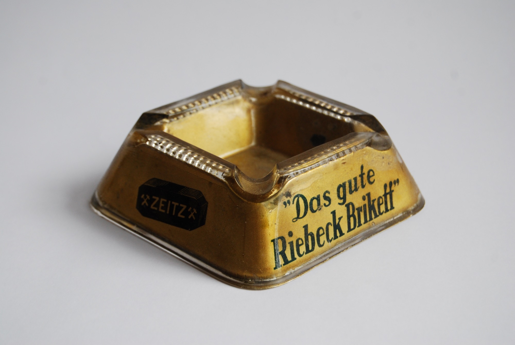 Gläserner Aschenbecher mit Werbung für Riebeck Brikett und Grudekoks (Museum Schloss Moritzburg Zeitz CC BY-NC-SA)