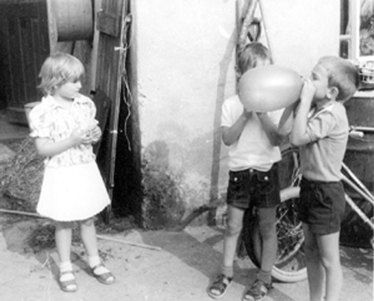 Zwei Jungen und ein Mädchen beim Luftballon aufblasen (Haus der Geschichte Wittenberg RR-F)