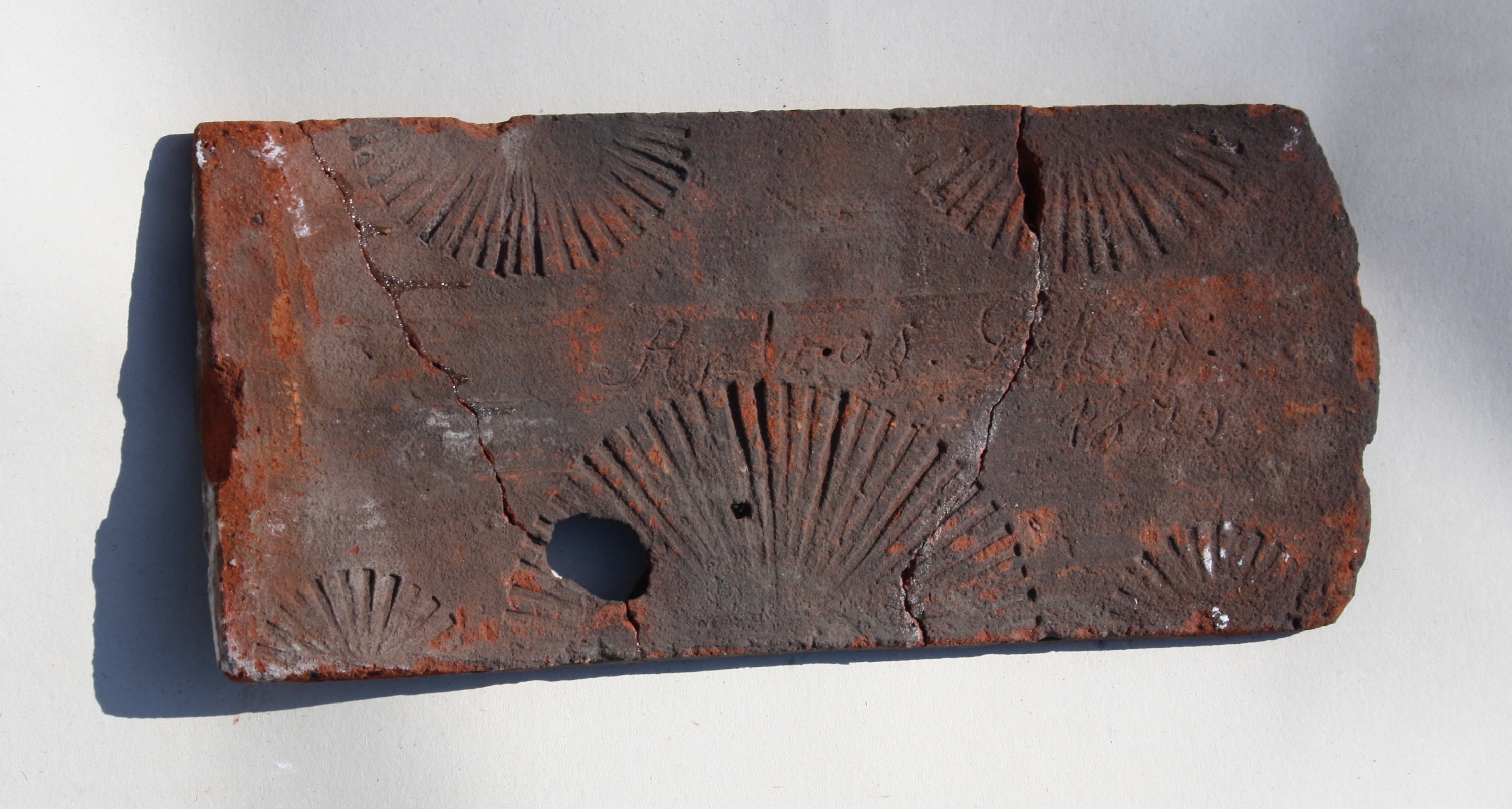 Feierabendziegel mit einem fächerartigen Muster und einer Inschrift (Kreismuseum Jerichower Land, Genthin CC BY-NC-SA)