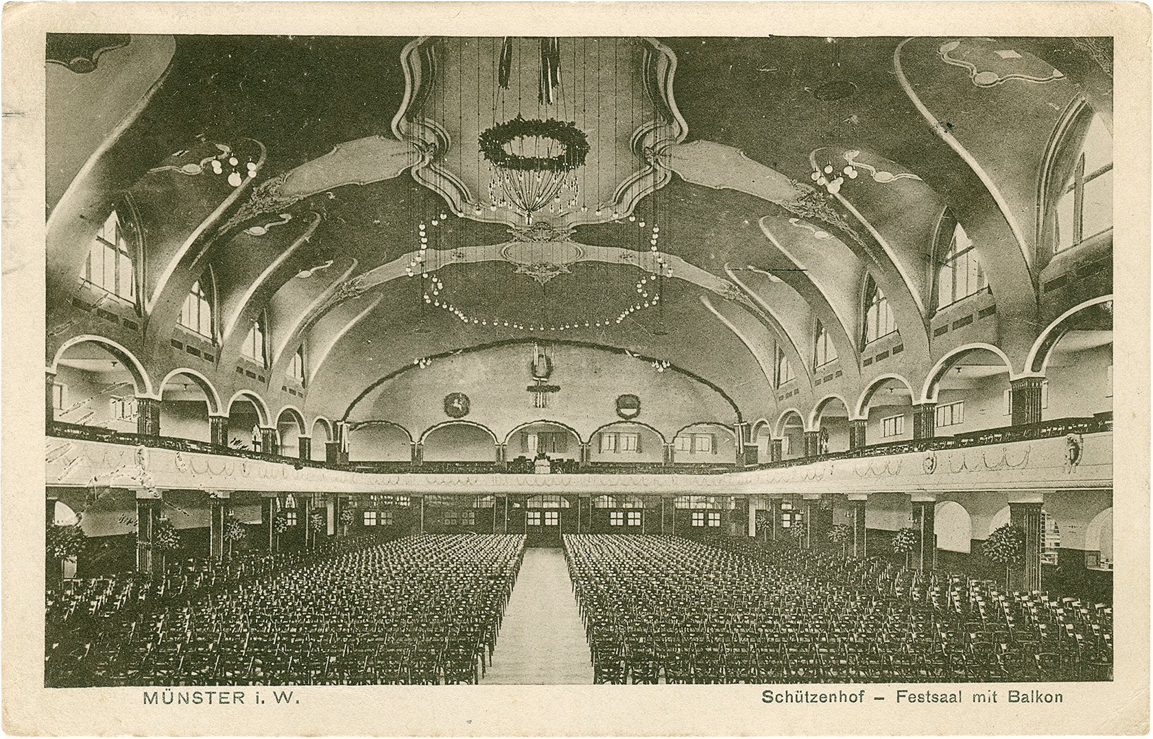 Postkarte: Blick in den großen Festsaal des Schützenhofes in Richtung Balkon mit vollständiger Bestuhlung. (Stadtmuseum Münster CC BY-NC-SA)