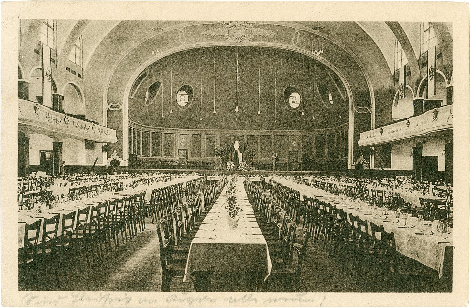Postkarte: Blick in den großen Festsaal des Schützenhofes in Richtung Bühne mit festlich gedeckten Tischreihen. (Stadtmuseum Münster CC BY-NC-SA)
