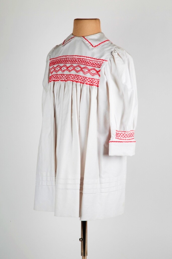 Kinderkleid aus weißem Baumwollköper und Smokarbeit (Stadtmuseum Lippstadt RR-F)